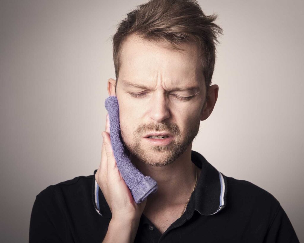 Patient using a cold compress after wisdom teeth removal